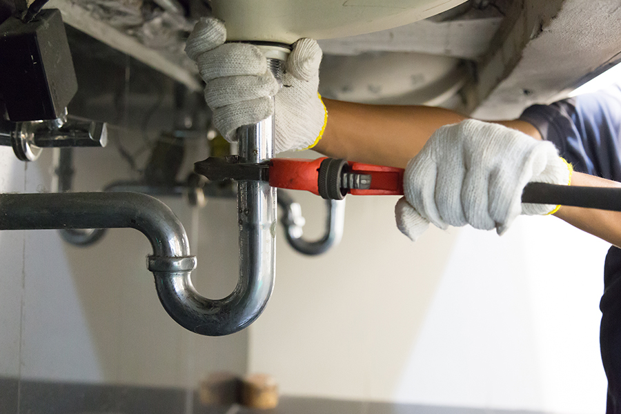 Plombier en dépannage sur un siphon d'évier